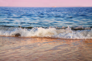 Wave hitting a beach at sunrise